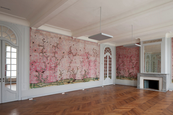 grote salon met houten vloeren en roze behang